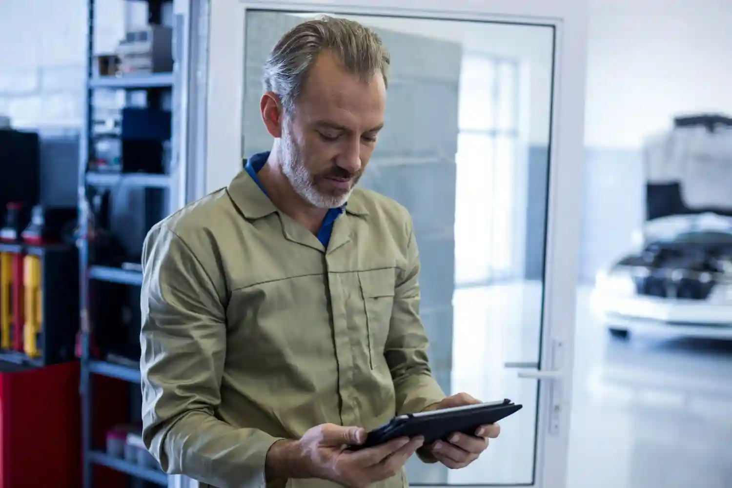 A-man-holds-a-tablet-focused-on-key-features-of-a-real-time-energy-monitor